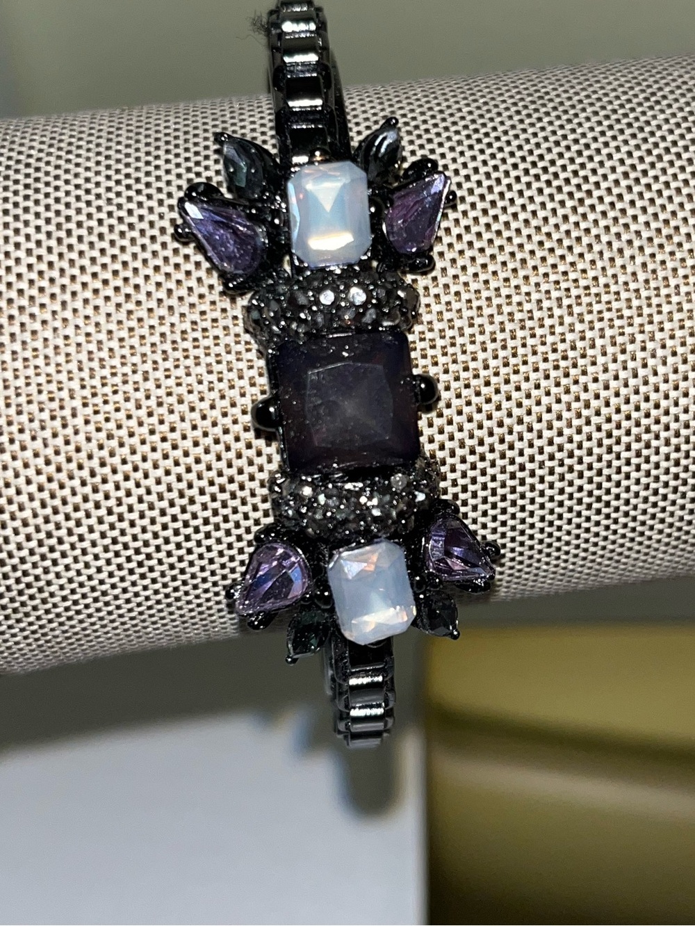 Vintage-like metal bracelet with purple and iridescent stones and link design.
